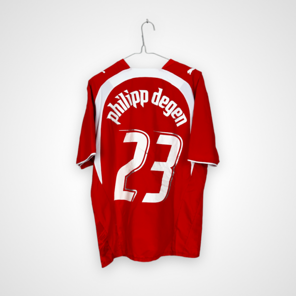 Koszulka piłkarska Szwajcaria, 2006/08 Home, stan dobry - delikatnie popękane cyfry, rozerwanie materiału na plecach oraz kilka mikro zaciągnięć.