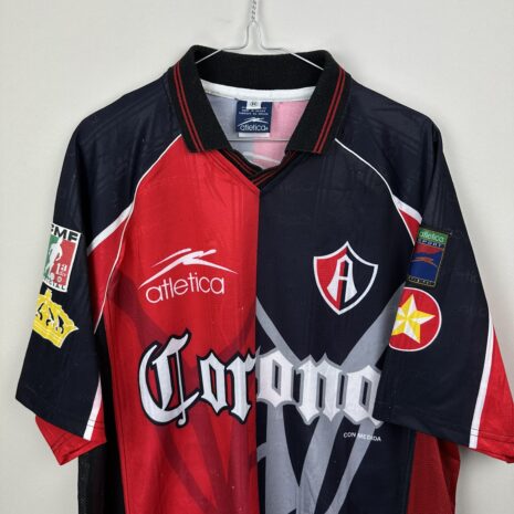 IMG_8066 Atlas FC Fußballtrikot, 1998 Home, zufriedenstellender Zustand - erhebliche Anzahl von Mikrodehnungen und einige recht große auf der Vorderseite - Nahaufnahme der Vorderseite