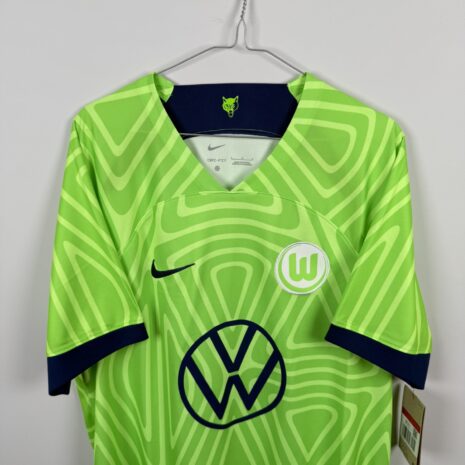 IMG_8854 VFL Wolfsburg Fußballtrikot, 2022/23 Home, neuwertiger Zustand - Trikot neu, mit Etikett, hat jedoch einen Mikrozug auf dem Rücken - Nahaufnahme der Vorderseite