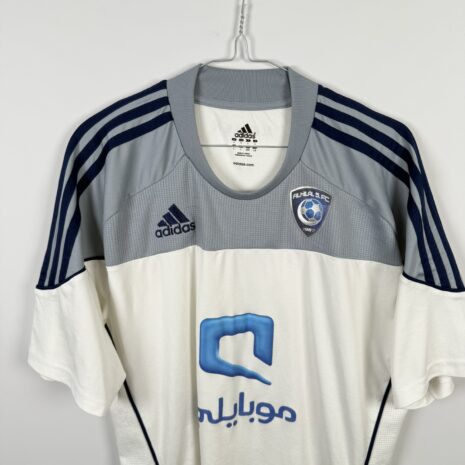 IMG_9741 Koszulka piłkarska AL Hilal SFC, 2010/11 Away, stan dobry - uszkodzony napis 'formotion', mikro pęknięcia wokół nadruku sponsora oraz jedno drobne zaciągnięcie.-