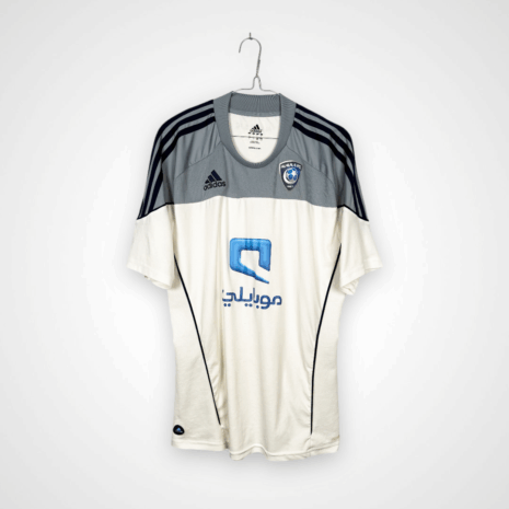 Koszulka piłkarska AL Hilal SFC, 2010/11 Away, stan dobry - uszkodzony napis 'formotion', mikro pęknięcia wokół nadruku sponsora oraz jedno drobne zaciągnięcie.